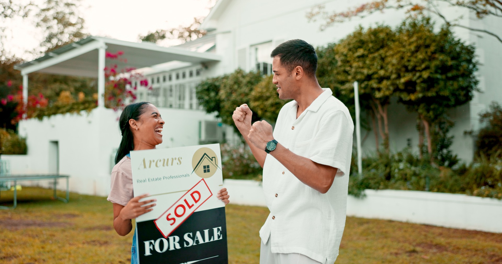 Celebration, excited and couple with sold sign, new home and future property investment together. Love, mortgage and real estate, man and happy woman in garden at house with smile in neighborhood